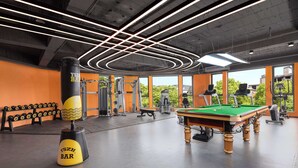 A gym with a pool table, exercise equipment, and large windows. - Days Hotel BY Wyndham Hengyang Nanyue (Hengyang)