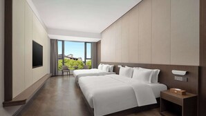 A modern hotel room with two beds, a TV, a bedside table, and a view of greenery outside. - Days Hotel BY Wyndham Hengyang Nanyue (Hengyang)