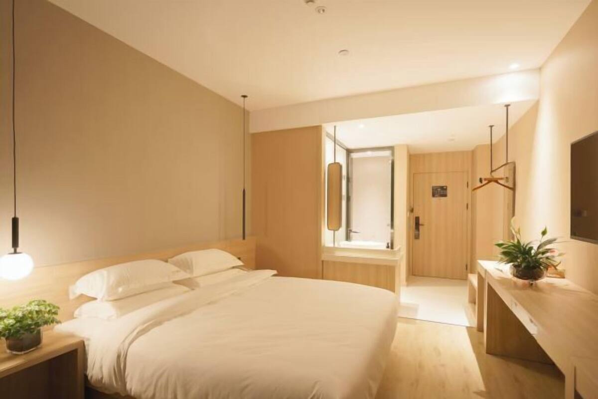 Ein modernes Schlafzimmer mit einem großen Bett, einem Nachttisch und einer Pendelleuchte.