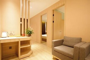 A room with a desk, a sofa, a bed, and a sliding door leading to another room. - Manring Hotel (Lijiang)