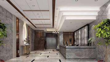 A modern hotel lobby with a reception desk, a large mirror, and a reception area.