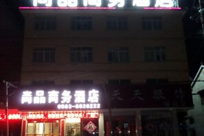 Een gebouw met een bord waarop 'Anquan Service Hotel' staat en een ander bord met Chinese karakters.