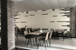 Un comedor moderno con detalles de ladrillo, un diseño de pared con motivos y mobiliario contemporáneo.