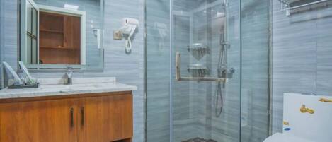 A modern bathroom with a glass-enclosed shower, a wooden vanity, and a white toilet.