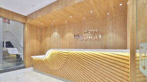 Un mostrador de recepción de hotel con detalles de madera y diseño moderno.