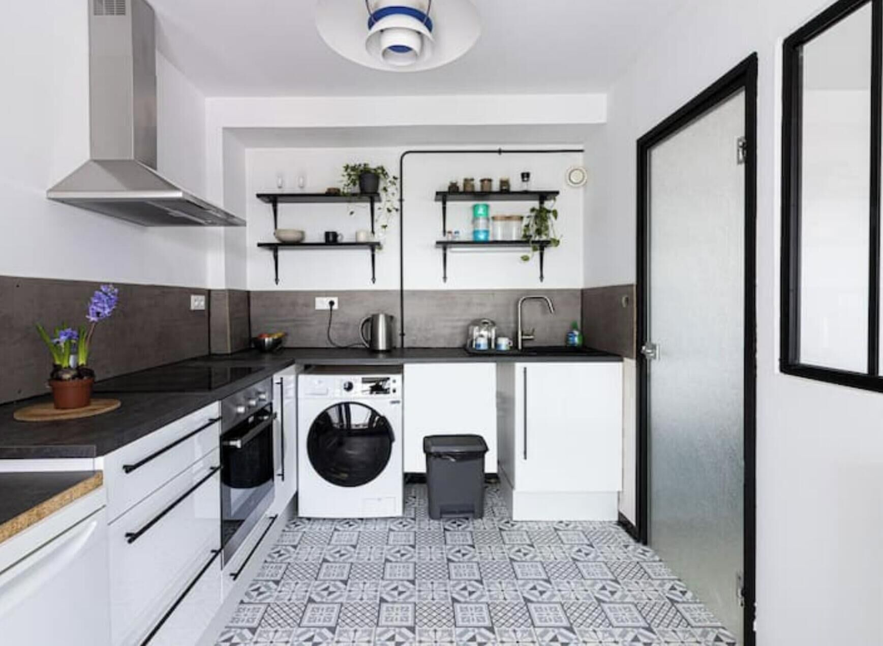 A compact kitchen with a washing machine, a sink, and a stove.