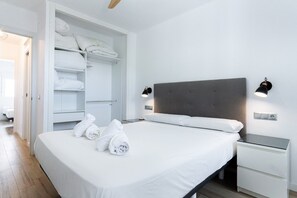 A hotel room with a bed, a wardrobe, and two bedside lamps.
