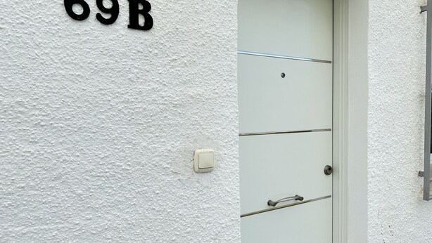 Una puerta blanca con el número 69B en la pared de arriba.