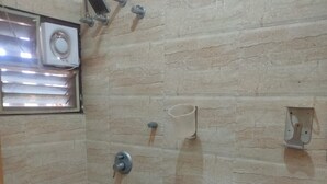 Un baño con ducha, inodoro y ventana.
