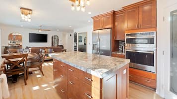 A modern kitchen with wooden cabinets, stainless steel appliances, and a granite countertop.