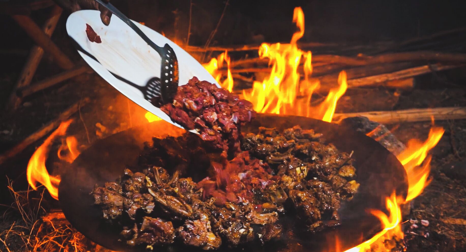 A pan of food being cooked over an open fire.