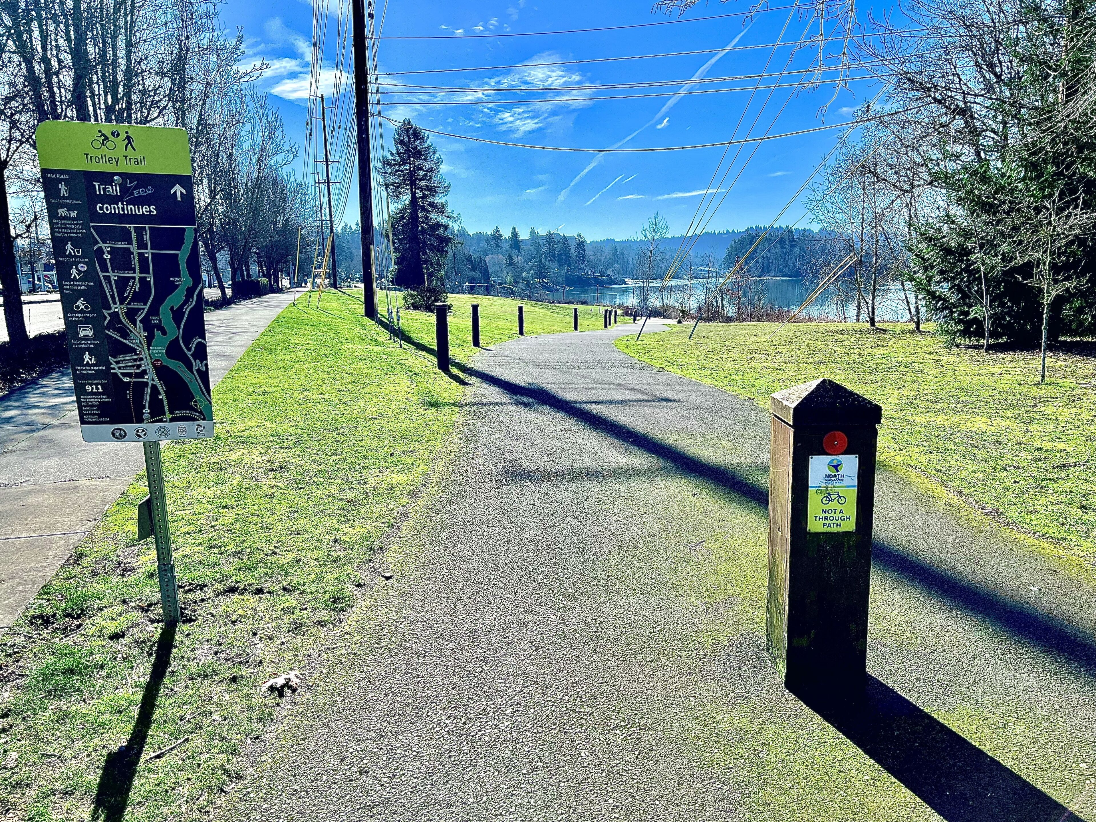 A clear path leading to a trolley trail sign with directional information.