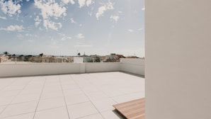 A rooftop terrace with a clear view of the city skyline and a tiled floor. - Apartamentos SubUp (Cartagena)