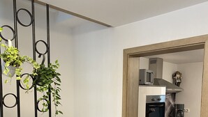 Cozinha moderna com armários brancos, micro-ondas e cafeteira.