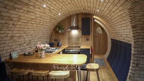 Een gezellige keuken met een bakstenen plafond, een houten aanrecht en krukken.