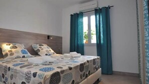 Ein Schlafzimmer mit Bett, Vorhängen und einem Fenster.