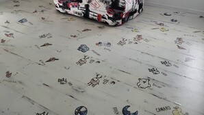 Une pièce avec un plafond en pente, une seule fenêtre et un sol à motifs.
