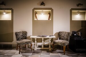 Una stanza con due poltrone a motivi zebrati, un tavolo bianco e un'apertura con la sagoma di una zebra.