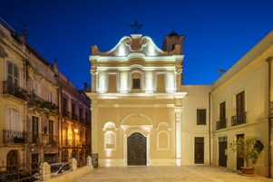 Un edificio storico con un ingresso centrale, affiancato da balconi e un cortile interno.