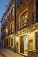 Un edificio con diversi balconi, una porta con un cartello e un lampadario sopra la porta.