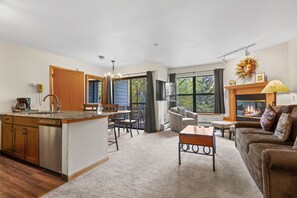 Una cocina moderna con comedor, una chimenea y una sala de estar acogedora con sofá y mesa de centro.