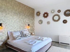 Ein Schlafzimmer mit einem Bett, Wandspiegeln und einer Heizung.