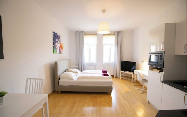 Enjoy a compact room with a single bed, kitchenette, and large window offering a view of the outdoors.