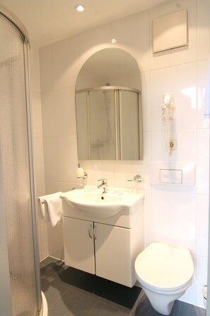 A bathroom with a sink, mirror, and toilet. - Gästehaus am Lausitzring (Sallgast)