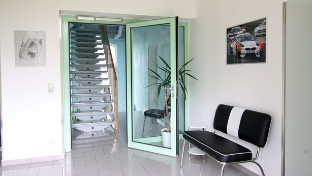 A modern interior with a staircase, a bench, and a framed picture on the wall. - Gästehaus am Lausitzring (Sallgast)