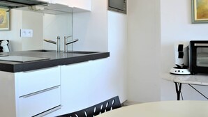 Eine moderne Küche mit schwarzem Arbeitsplatz, Edelstahlgeräten und weißen Schränken.