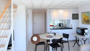 Eine moderne Küche mit Essbereich, einer Treppe und Blick ins Freie.