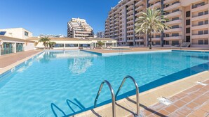 Une piscine à l’eau d’un bleu limpide, entourée d’une terrasse carrelée.