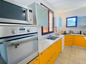 Una cucina con forno a microonde, forno e lavello.