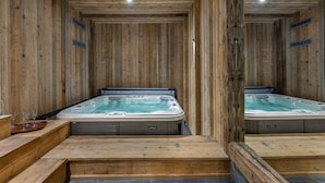 A wooden spa room with two hot tubs and wooden steps leading to them. - Luxury chalet, jacuzzi and sauna, sleeps 14. (Val-d'Isère)