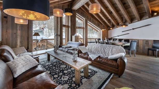 A spacious living area with a wooden ceiling, leather sofas, a coffee table, and pendant lights. - Luxury chalet, jacuzzi and sauna, sleeps 14. (Val-d'Isère)