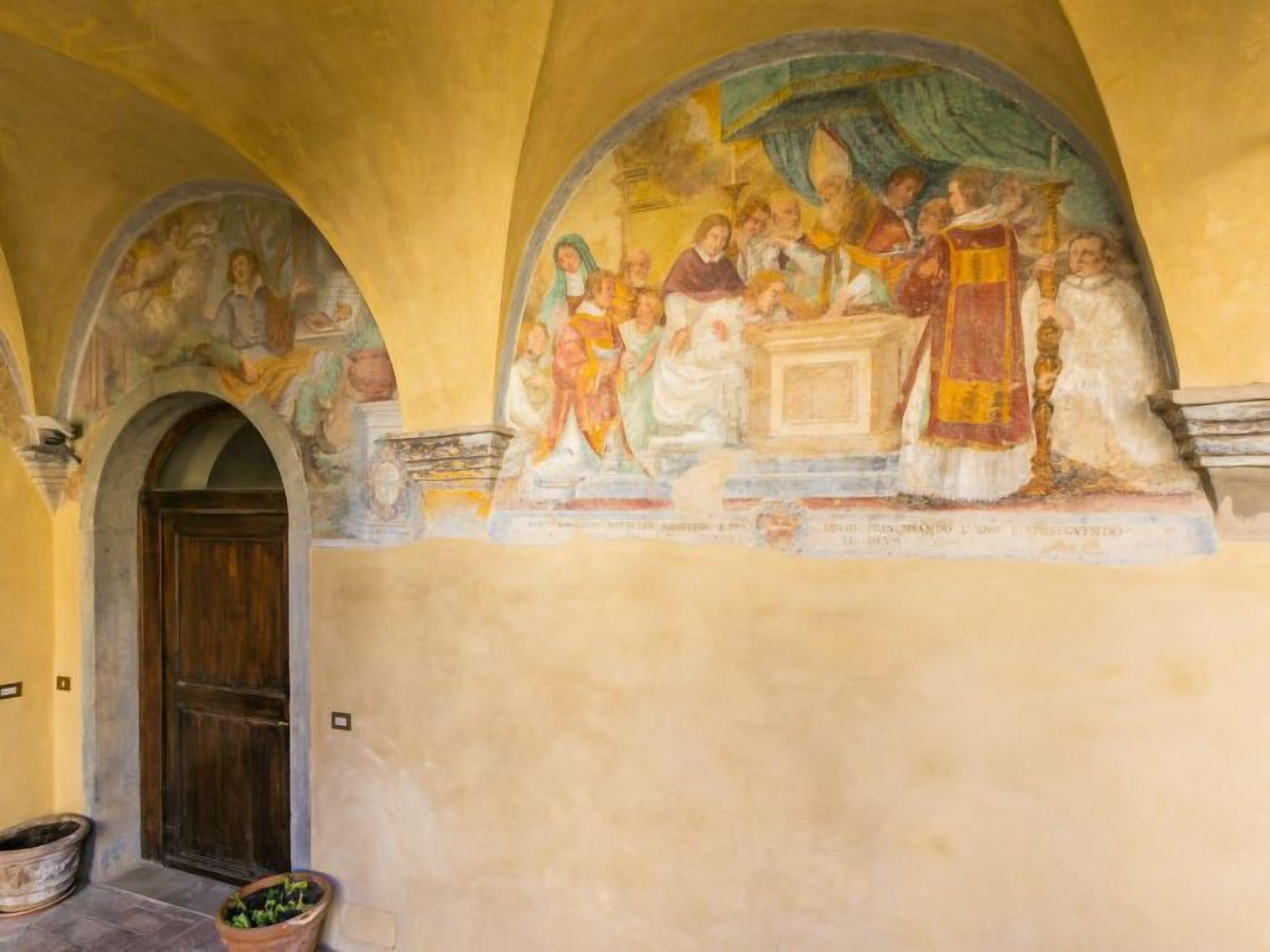 A hallway with a fresco mural depicting a historical scene.