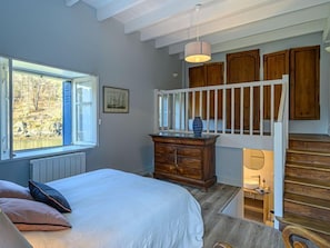 A bedroom with a bed, dresser, and a view of the outdoors through a window. - Glann Aven by Interhome (Le Bono)
