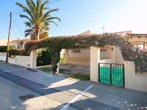 A residential street with a house featuring a covered driveway and a green gate. - Molines by Interhome (Calpe/Calp)