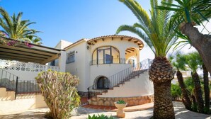 Una casa de dos pisos con fachada de piedra, un balcón y una escalera de piedra que conduce al nivel superior.