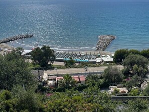 A coastal area with a beach, a rocky breakwater, and a row of buildings with a swimming pool. - Caterina by Interhome (Marina di Andora)
