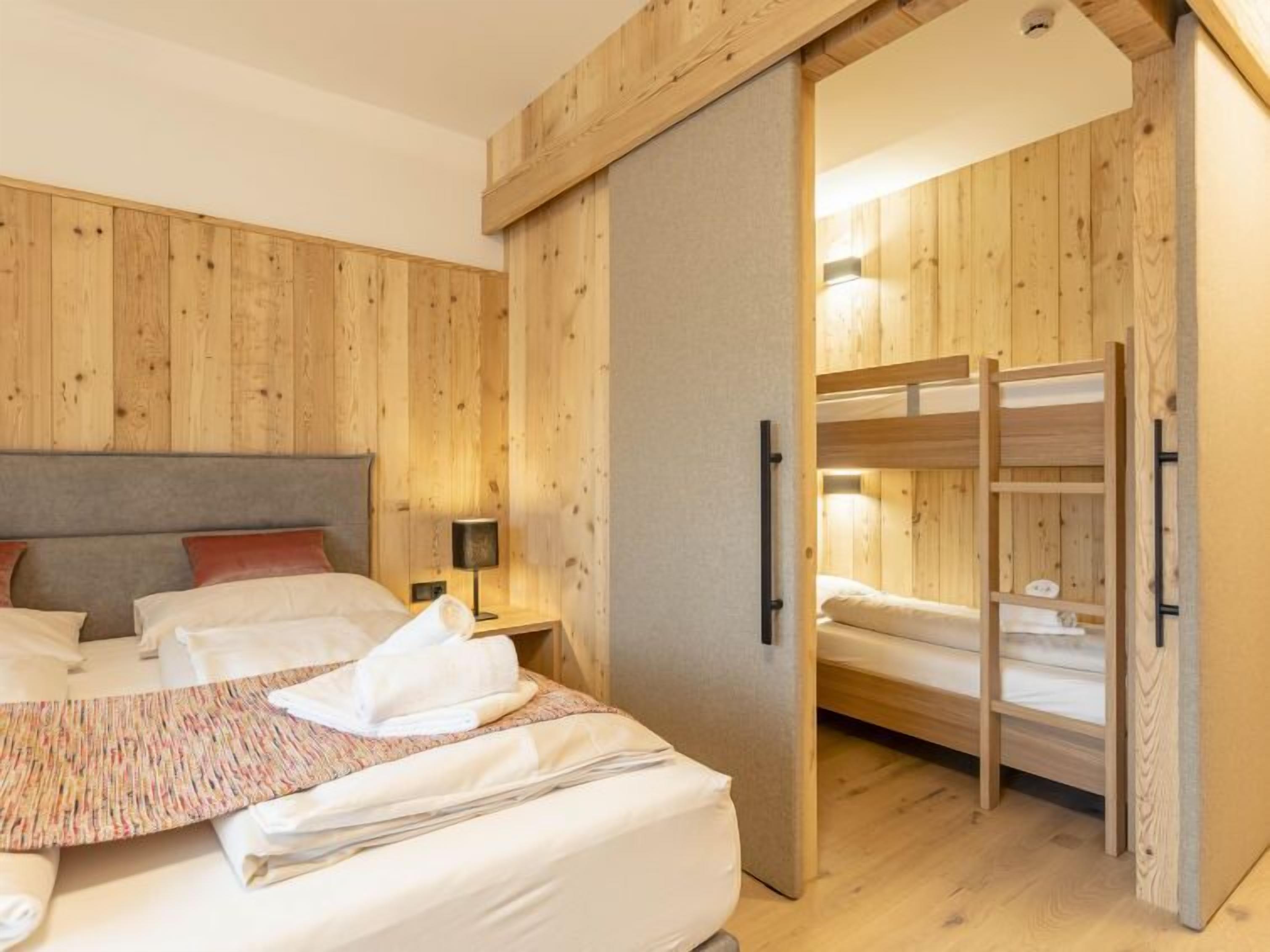 Una camera da letto con un letto, un comodino, una lampada e un'armadio in legno.