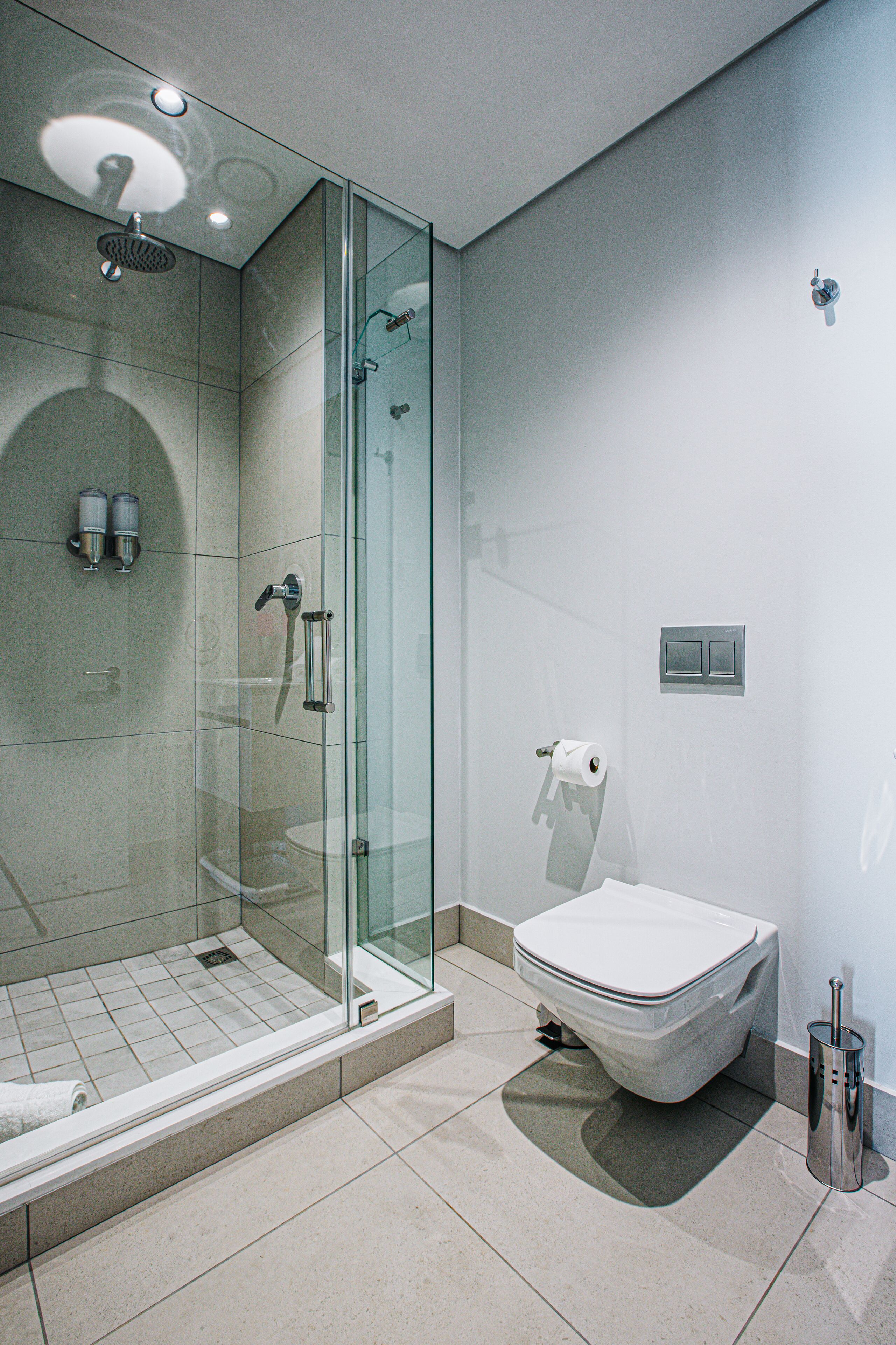 Une salle de bain moderne dotée d’une douche à parois de verre, de toilettes et d’un bidet.