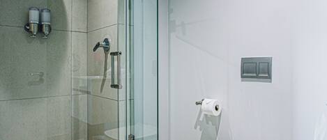 Un baño moderno con ducha de vidrio, inodoro y bidé.