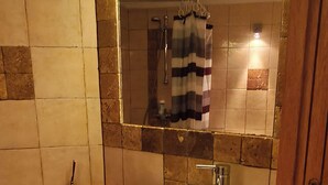 A bathroom with a large white sink, a mirror above it, and a shower area. - An old oil press nestled between the sea and hiking trails (Santa-Reparata-Di-Balagna)