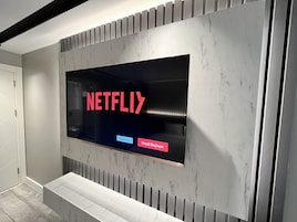 Una pared moderna con una pantalla grande mostrando el logotipo de Netflix.