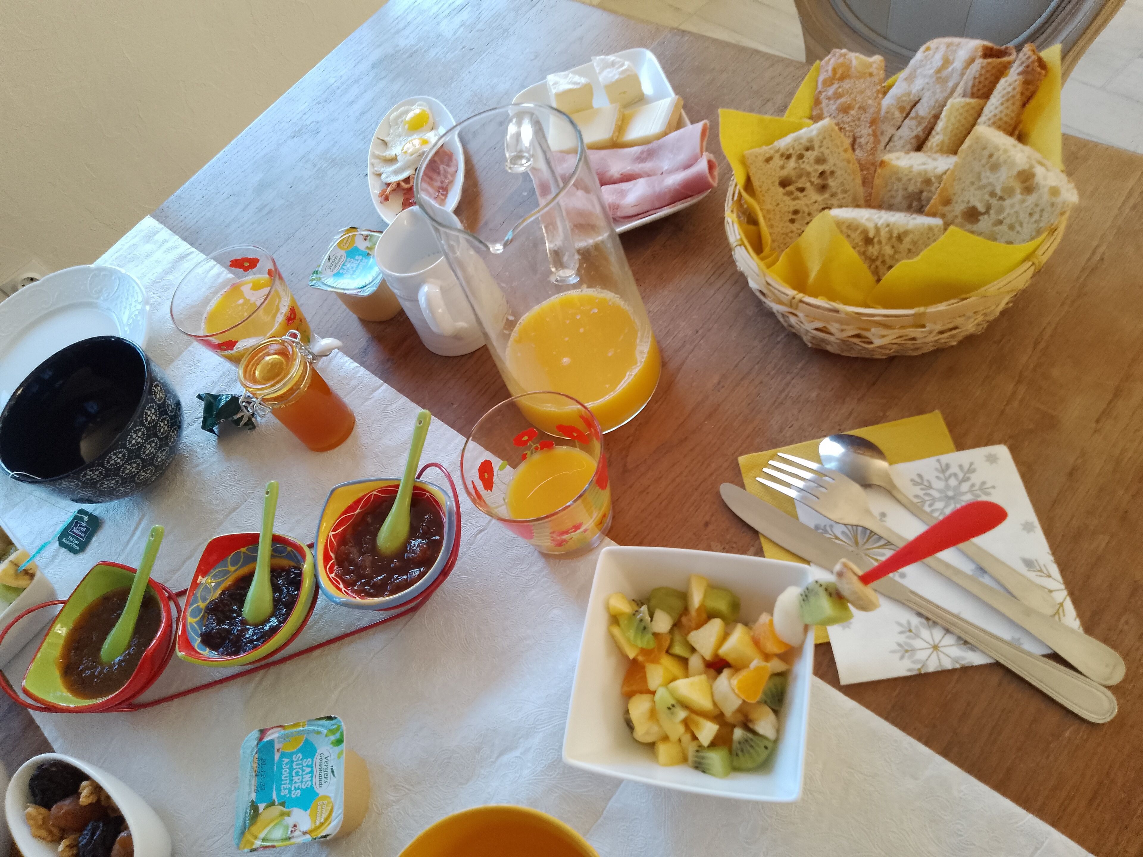 Een ontbijttafel met diverse soorten eten, zoals eieren, brood en fruit.