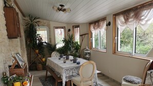 Un comedor acogedor con una mesa de madera, sillas y plantas en macetas.