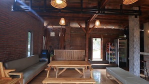 Un interior rústico de madera con sofá, banco y mesa de comedor.