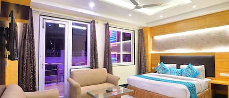 Una habitación de hotel con una cama, un sofá y una mesa de centro de vidrio.