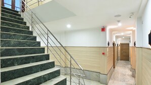A modern hotel interior with marble stairs, a wooden hallway, and a view of the corridor. - Hari Piorko Grand (New Delhi)